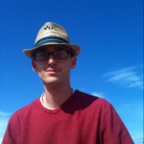 Carlton Gibson, in a straw hat, against a blue sky.